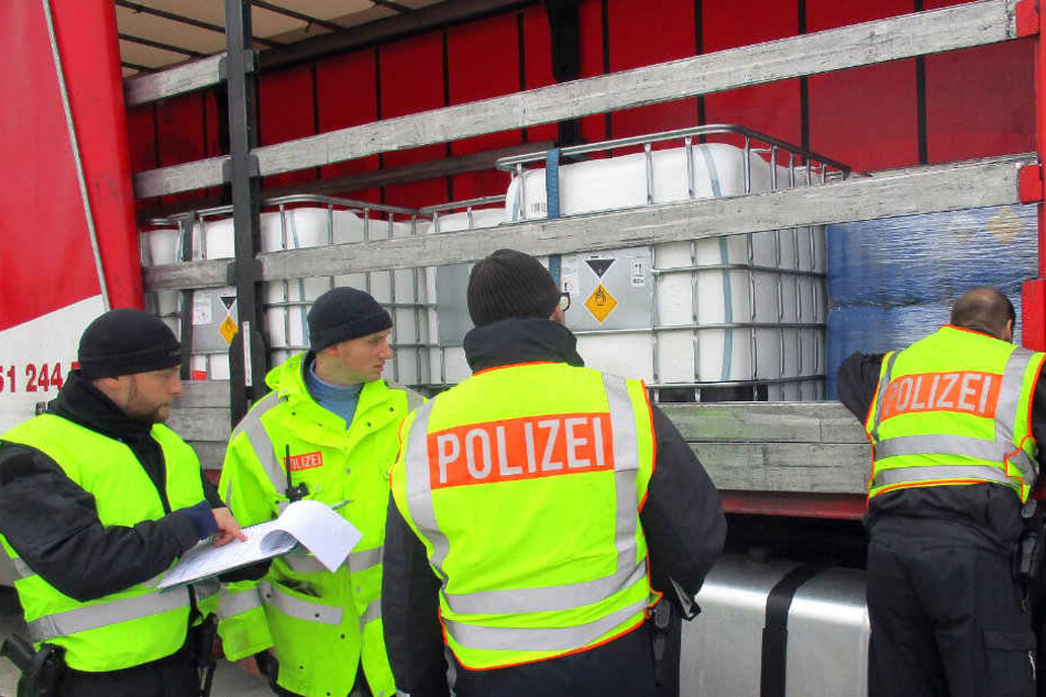 Beamte kontrollieren einen Gefahrgut-Laster.
