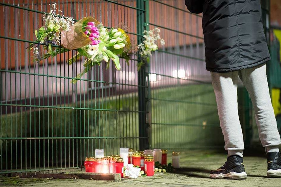 Trauernde haben Kerzen und Blumen am Zaun der Schule abgelegt.