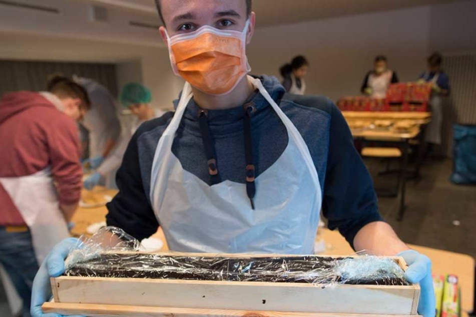 Ein Schüler zeigt einen weiteren Baustein für den Rekordkuchen.