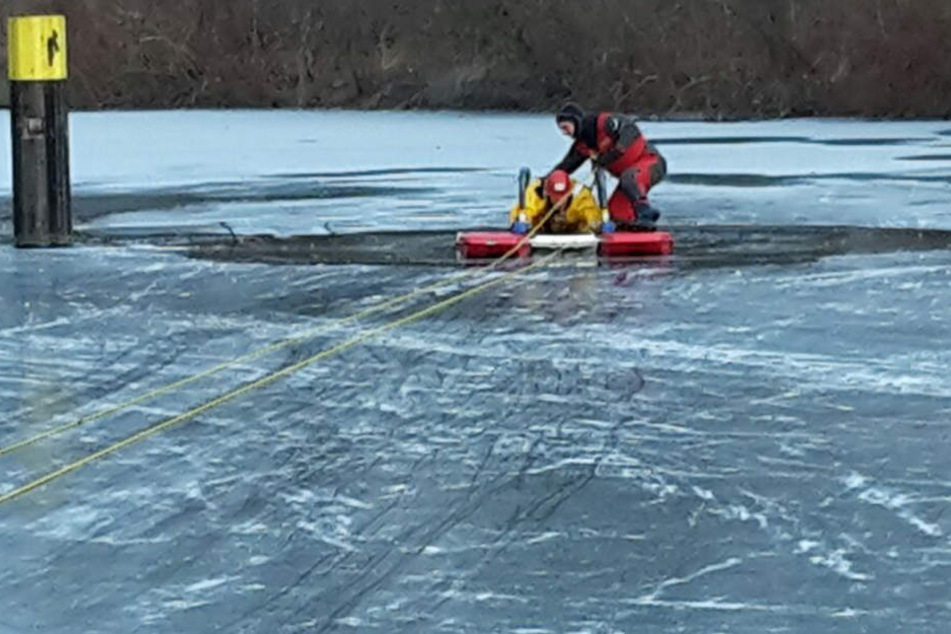 Feuerwehrmänner suchen im eisigen See nach einem untergegangenen Mensch. (Symbolbild)