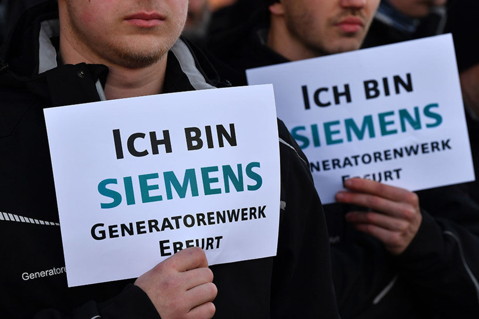 Beschäftigte des Siemens-Generatorenwerkes in Erfurt halten Schilder mit der Aufschrift "Ich bin Siemens. Generatorenwerk Erfurt" in den Händen.
