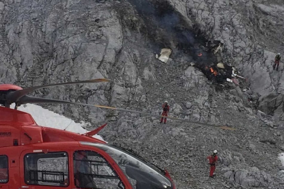 Rettungskräfte stehen an der Unfallstelle.