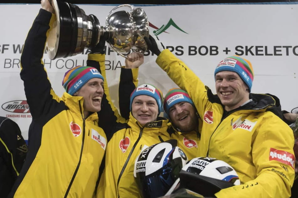 Thorsten Margis (l-r), Francesco Friedrich, Martin Grothkopp und Candy Bauer aus Deutschland halten die Trophäe.