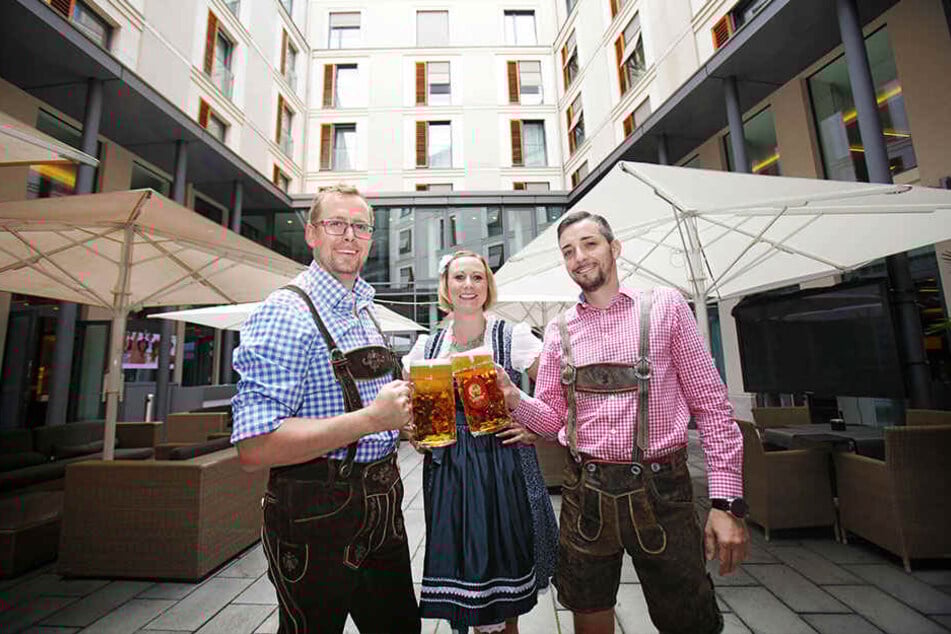 Die Innside-Hotelmitarbeiter Robert Straboth (41), Katharina Mohaupt (32) und Ronny Richter (36, v.l.) stoßen in Tracht auf das Oktoberfest an.