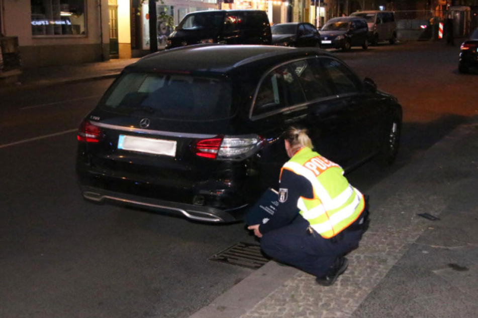 Eine Polizistin begutachtet den Mercedes.