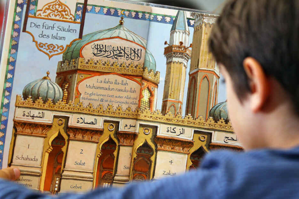Das Bild aus dem Juni 2018 zeigt ein Jungen, der während des islamischen Religionsunterrichts in einem Schulbuch liest.