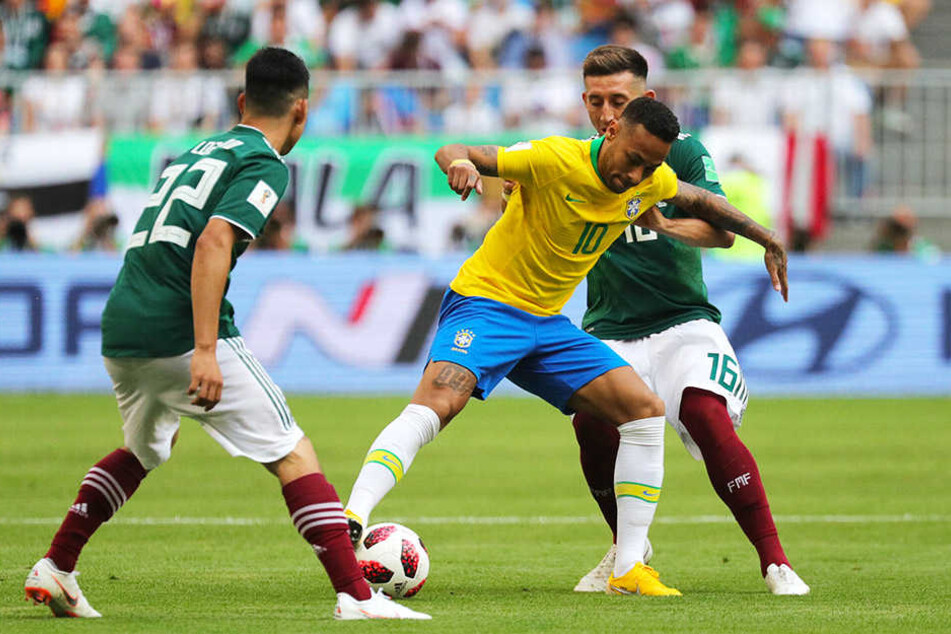 Mit neuer Frisur: Brasiliens Superstar Neymar (M.) muss sich der harten Gegenwehr der Mexikaner Hirving Lozano (l.) und Héctor Herrera (hinten) erwehren.