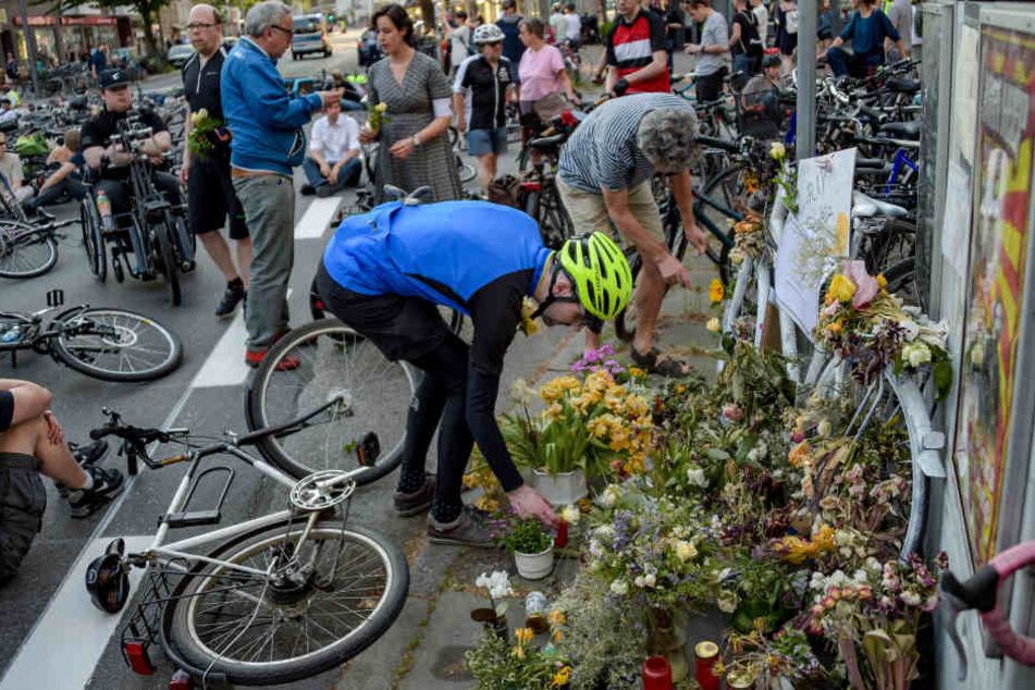Radfahrer legen beim "Ride of Silence" am Unfallort Blumen nieder.
