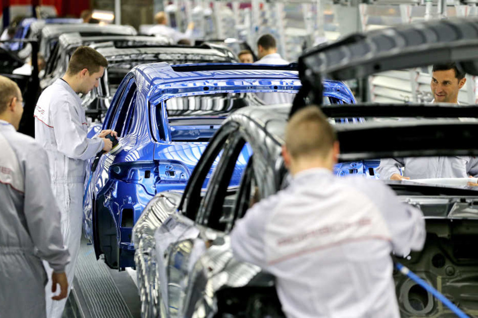 Porsche-Mitarbeiter kontrollieren in einem Lichttunnel die Lackierung von Porsche Macan im Werk Leipzig. (Archivbild)