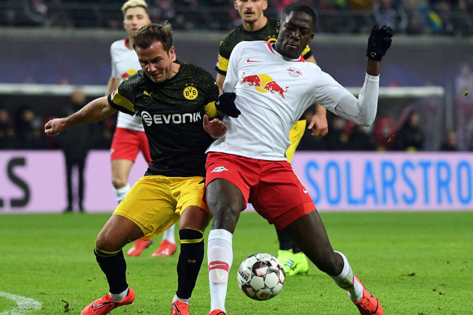 BVB-Star Mario Götze (l.) versucht, sich gegen RB Leipzigs Abwehrkante Ibrahima Konaté (r.) durchzusetzen.