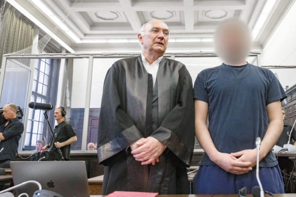 Der Angeklagte Yamen A. steht im Gerichtssaal neben seinem Verteidiger.