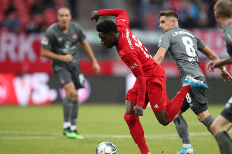 Alphonso Davies spielt den Ball vor seinem Treffer zum 1:1 neben den beiden Nürnbergern Nikola Dovedan (2.v.r.) und Lukas Jäger (r).