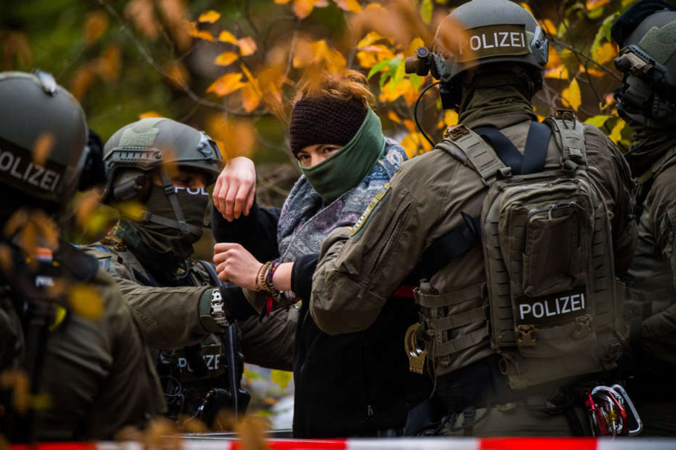 Die Beamten führen eine der Protestantinnen ab.