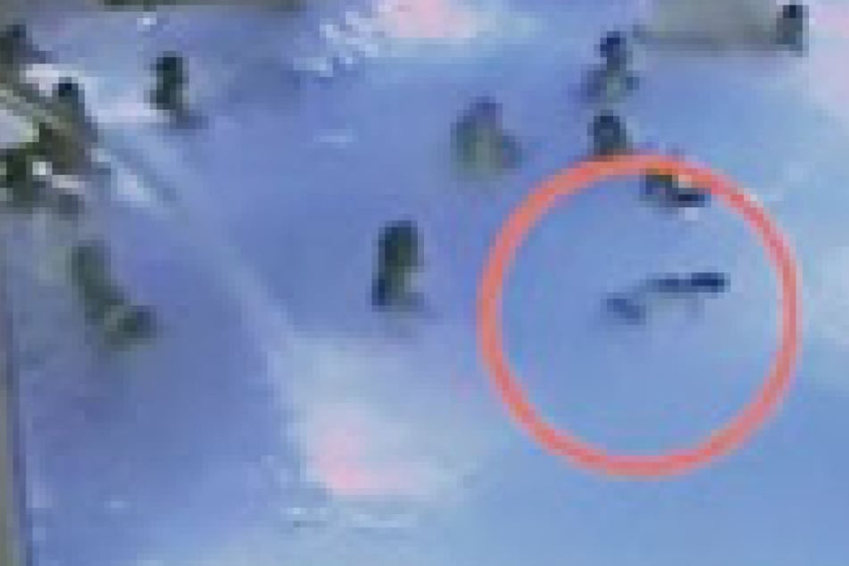 Der Junge treibt leblos durch das Schwimmbecken, doch die Badegäste interessiert es absolut nicht.