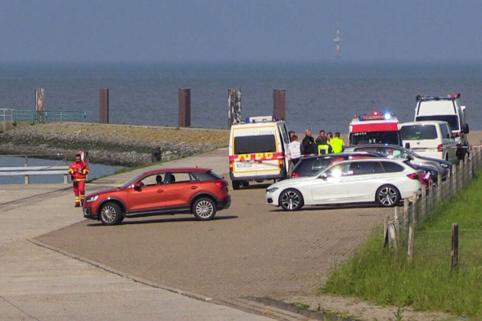 Helfer der Deutschen Lebens-Rettungs-Gesellschaft stehen bei einer Suchaktion auf einem Parkplatz.