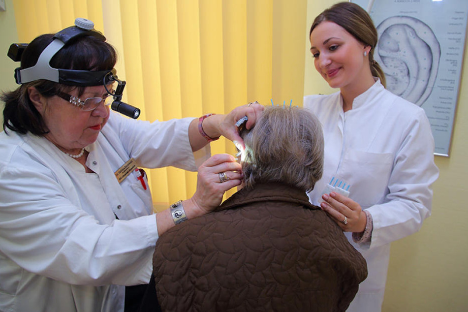Mit Fingerspitzengefühl setzt die Chef-Allergologin der Uniklinik, Dr. Bettina Hauswald, die Akupunktur-Nadeln punktgenau
am Ohr ihrer Patientin. Doktorandin Henriette Scheibner (24, r.) assistiert.