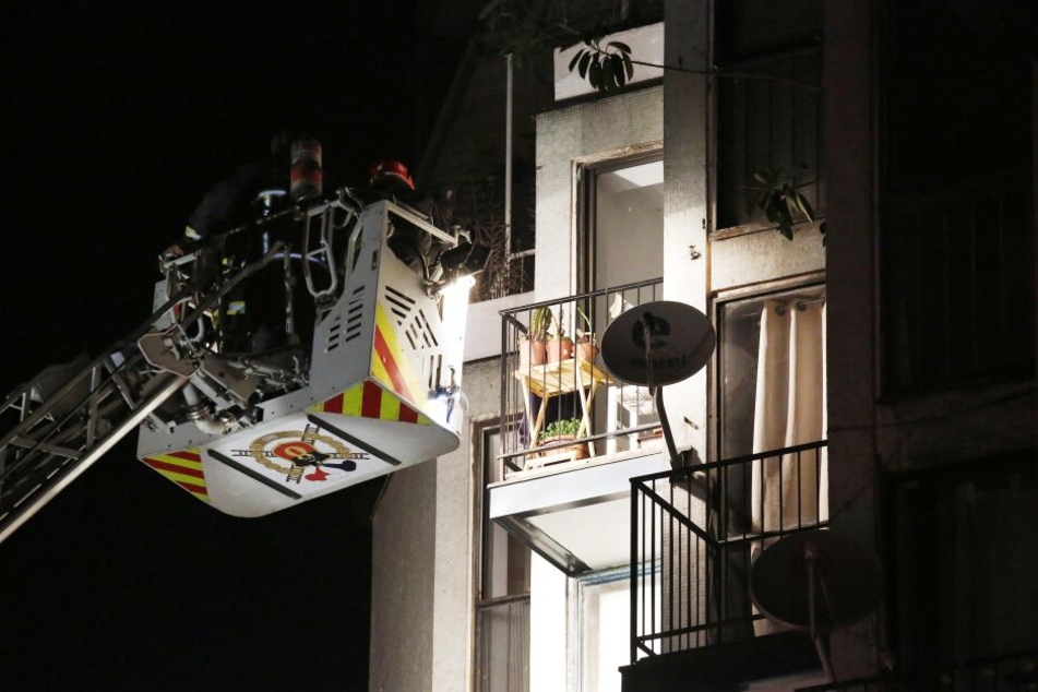 Feuerwehrleute betreten mit Hilfe eines Krans die Wohnung.