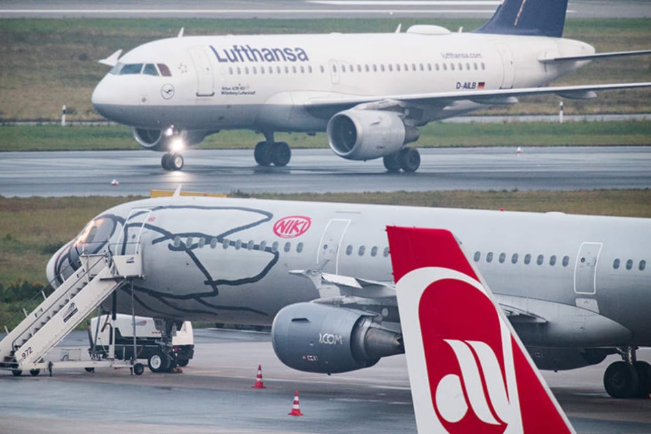 Ein Flugzeug der Fluggesellschaft Lufthansa rollt auf dem Flughafen Düsseldorf auf dem Vorfeld an Flugzeugen der Fluggesellschaften Niki und Air Berlin vorbei.