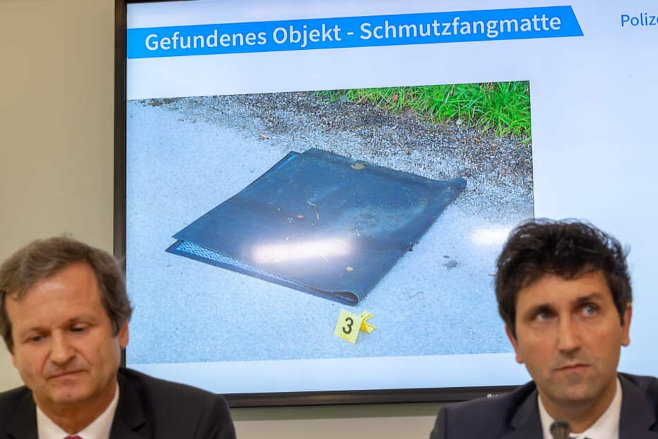 Ken Heidenreich (l), Staatsanwaltschaft München 1 und Josef Wimmer, Leiter Kommissariat 11 zeigen das Beweisstück Fußmatte.