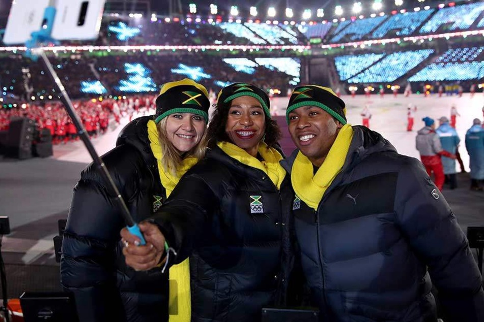 Sandra Kiriasis (l), macht mit Athleten aus Jamaika ein Selfie bei der Eröffnungsfeier der Olympischen Spiele in Pyeongchang.