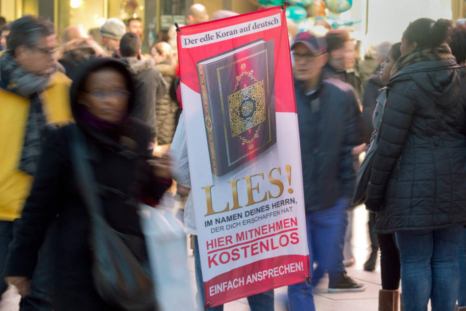 Mit einem Plakat auf dem Rücken versucht ein Salafist mit der Koran-Verteilaktion "Lies!"Aufmerksamkeit auf sich zu ziehen. Die Aktion ist inzwischen bundesweit verboten worden. (Symbolbild)