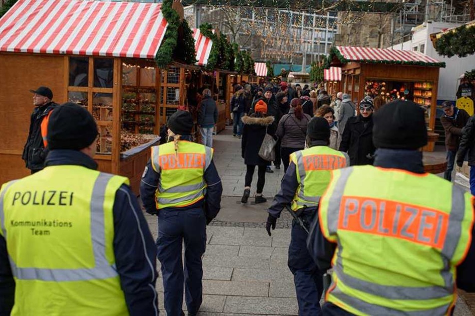 Polizeibeamte gehen über den Weihnachtsmarkt an der Gedächtniskirche auf dem Breitscheidplatz Streife.