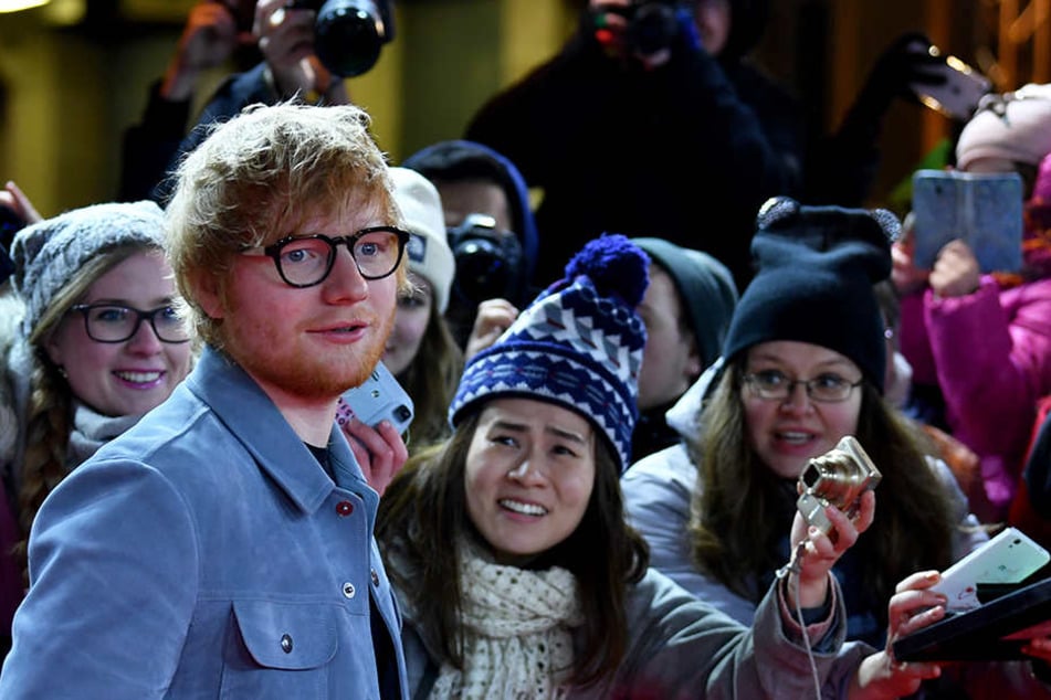 Ed Sheeran mit Fans am roten Teppich.