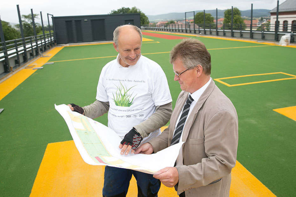 BSZ-Schulleiter Uwe Richter (55, r.) und Andreas Benz (58) vom Spiel- und Sportstätten-Service auf dem frisch verlegten Kunstrasen des Dach-Sportplatzes.
