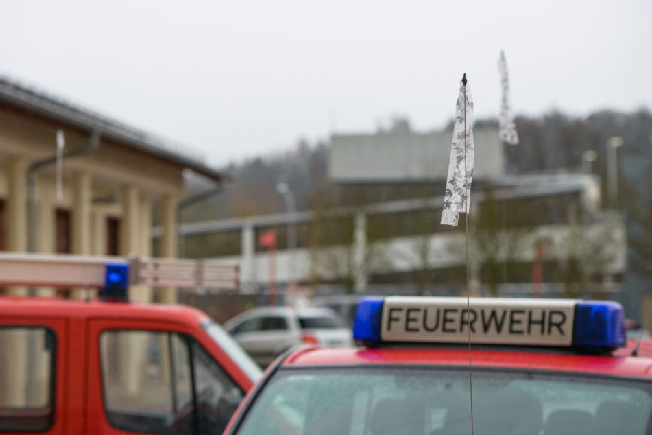 An den Fahrzeugen der Feuerwehr sind Trauerflore angebracht.