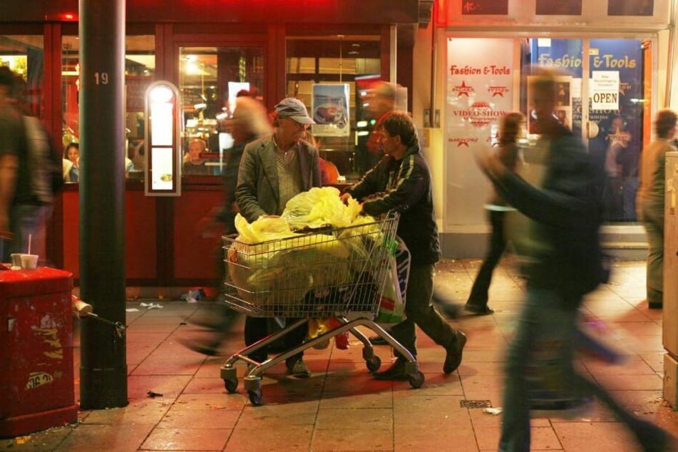 Flaschensammler schieben auf der Hamburger Reeperbahn einen Einkaufswagen voller Flaschen. Bis zu 40 Sammler sind an Wochenenden auf St. Pauli unterwegs. Es sind längst nicht mehr nur Obdachlose, die Flaschen sammeln.