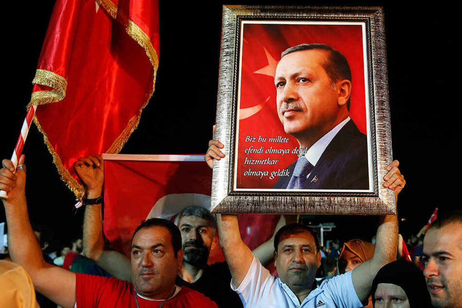 Anhänger halten ein Bild von Repec Tayyip Erdogan (64) hoch.