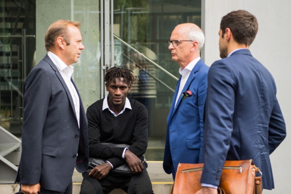 Der HSV-Profi sitzt neben Bernd Hoffmann (l), Vorstandsvorsitzender des HSV, auf dem DFB-Gelände auf einer Mauer.