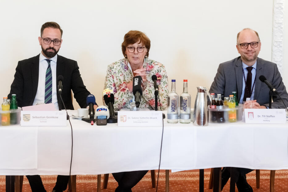 vlnr.: Sebastian Gemkow (CDU), Justizminister Sachsens, Sabine Sütterlin-Waack (CDU), Justizministerin Schleswig-Holsteins und Till Steffen (Bündnis 90/Die Grünen), Justizsenator Hamburgs, sitzen auf der Pressekonferenz zum Thema am reich gedeckten Tisch.