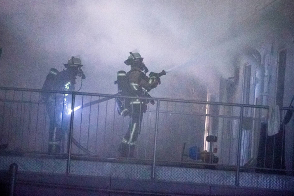 Einsatzkräfte in Atemschutzausrüstung kämpfen gegen den Brand an.