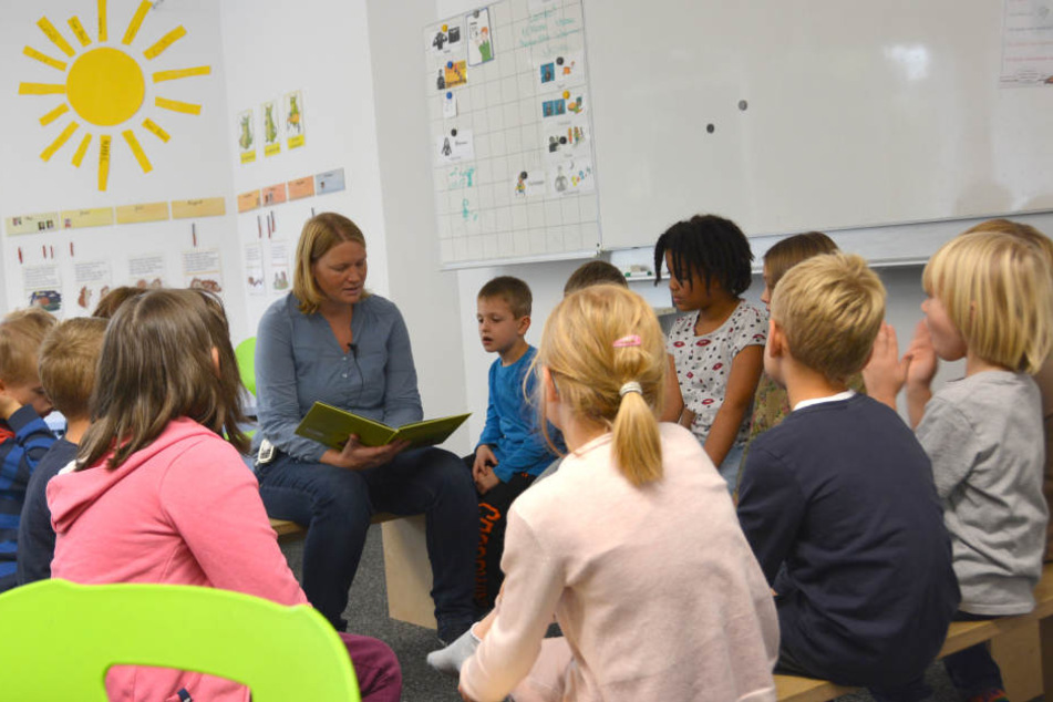 Die Lehrerin Anne Braun von der Padua Schule sitzt inmitten der Kinder während des Unterrichts.