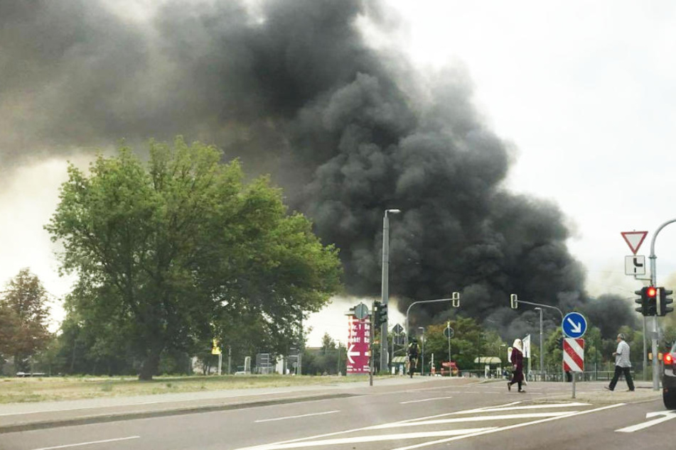 Eine riesige schwarze Rauchwolke ist weit über der Stadt zu sehen.