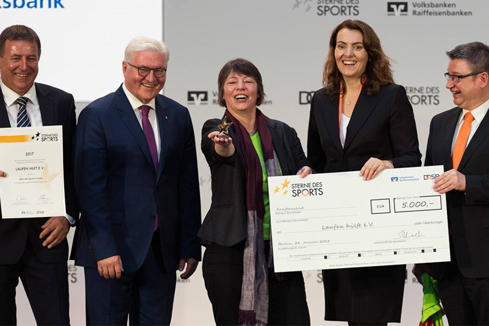 Frank-Walter Steinmeier (2.v.l.) und die Präsidentin des Bundesverbandes der Deutschen Volksbanken und Raiffeisenbanken, Marija Kolak (2.v.r.), neben Mitgliedern des Vereins "Laufen hilft e.V.".