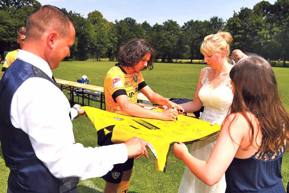 Nach dem Mannschaftsfoto signierten die Spieler, hier Matthäus Taferner, ein großes Dynamo-Trikot für Cindy und Robin Kühne.
