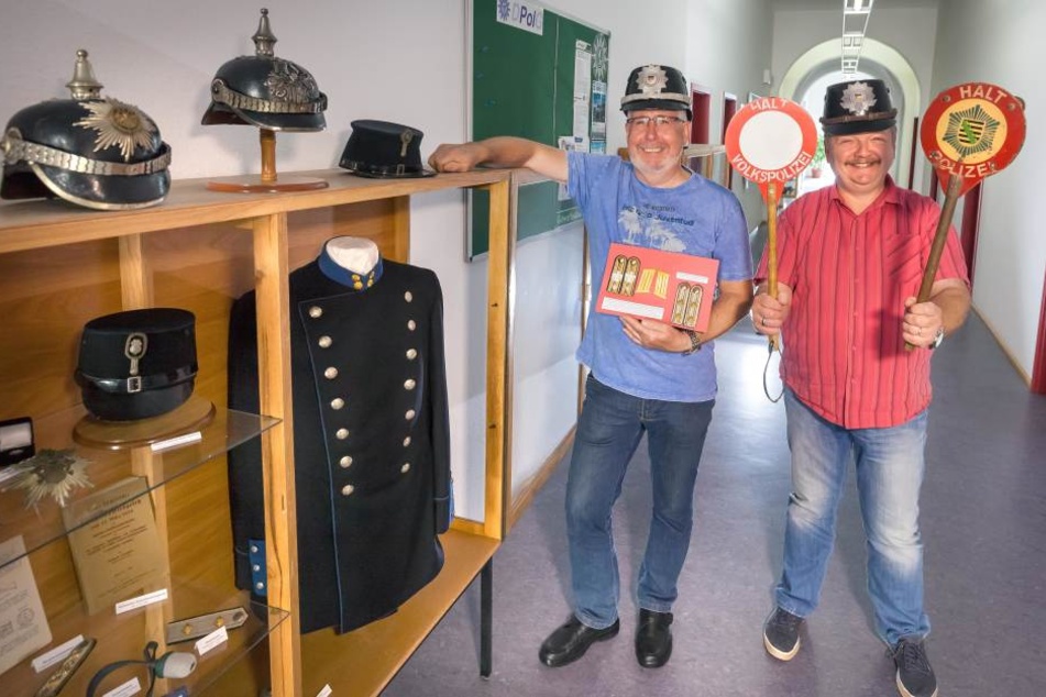 Die Polizeihauptmeister Roland Gräber (62) und PHM Udo Krahl (53, r.) mit den Sammelstücken im Marienberger Polizeirevier.
