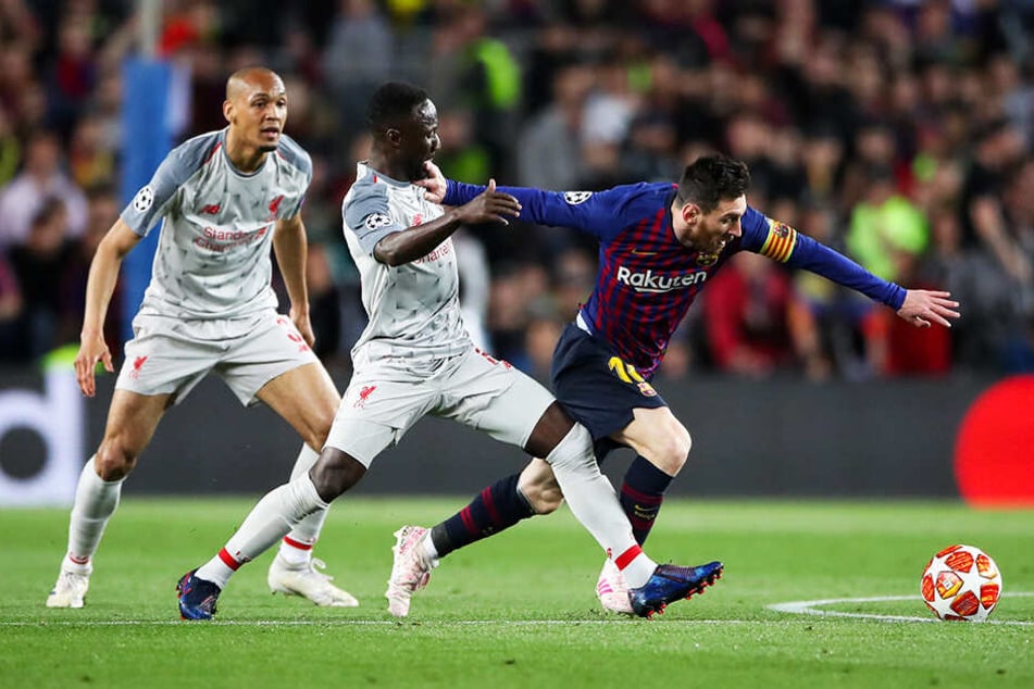 Barca-Superstar Lionel Messi (r.) wird von Liverpools spielstarkem Mittelfeldmann Naby Keita (M.) attackiert, der kurz darauf verletzt vom Feld musste.