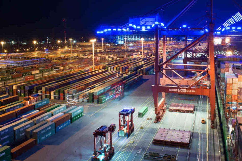 Zahlreiche "Van Carrier" fahren in der Nacht mit blauen Leuchtstoffröhren im Container-Terminal Eurogate in Hamburg umher.