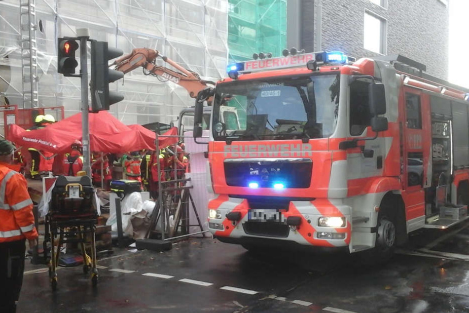Einsatzkräfte versuchen den Mann aus der Grube zu befreien.
