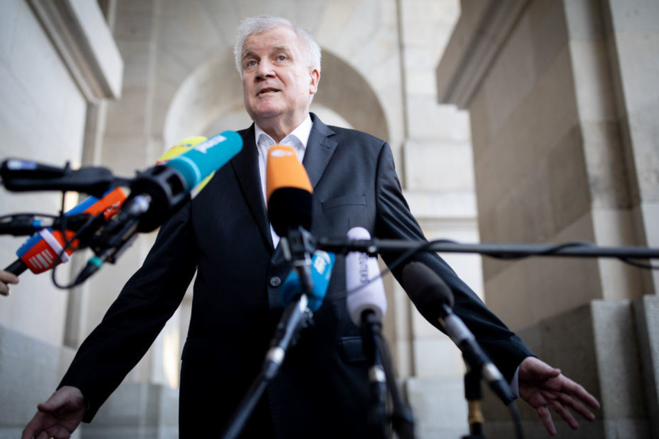 Host Seehofer äußert sich vor dem Reichstagsgebäude.