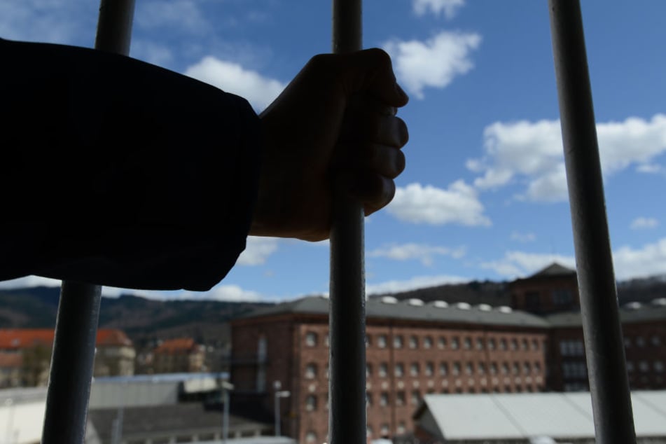 Ein Mann steht in der Justizvollzugsanstalt in Freiburg vor einem vergitterten Fenster. (Symbolbild)