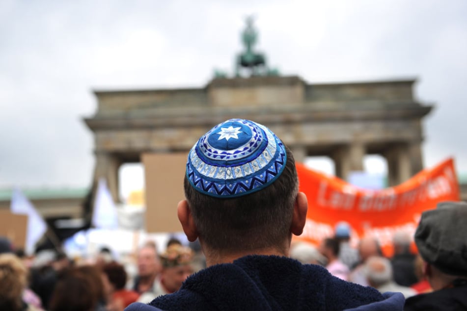 Teilnehmer der Kundgebung «Steh auf! Nie wieder Judenhass!» des Zentralrats der Juden in Deutschland stehen vor dem Brandenburger Tor in Berlin.