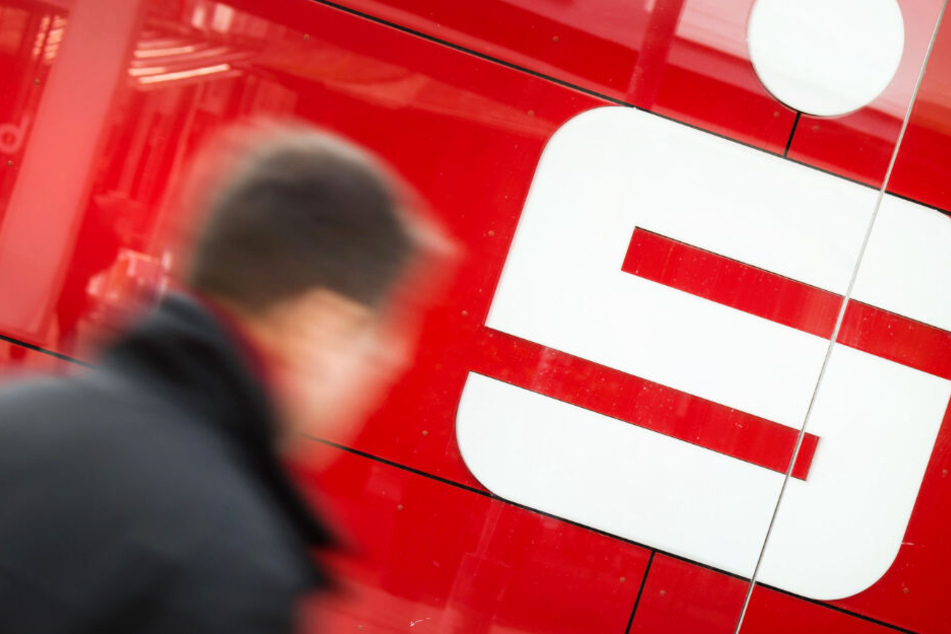 Ein Mann geht an einer Filiale der Sparkasse vorbei.