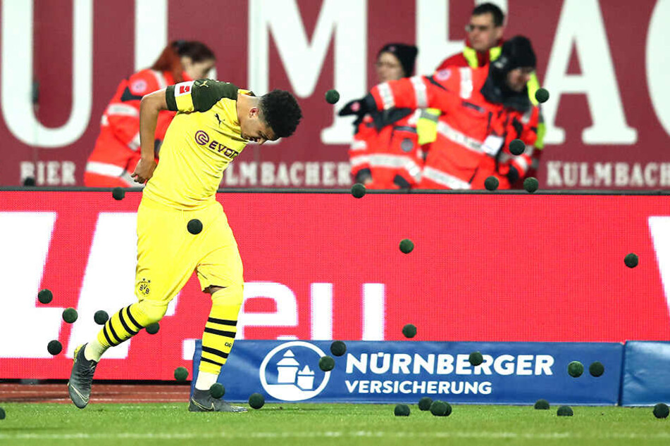 Jaden Sancho muss sich förmlich wegducken, weil die Wurfgeschosse auf ihn einprasseln.