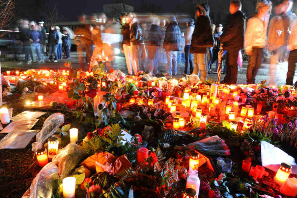 Trauernde stehen am 12.3.2009 vor einem Meer aus Grablichtern und Blumen.