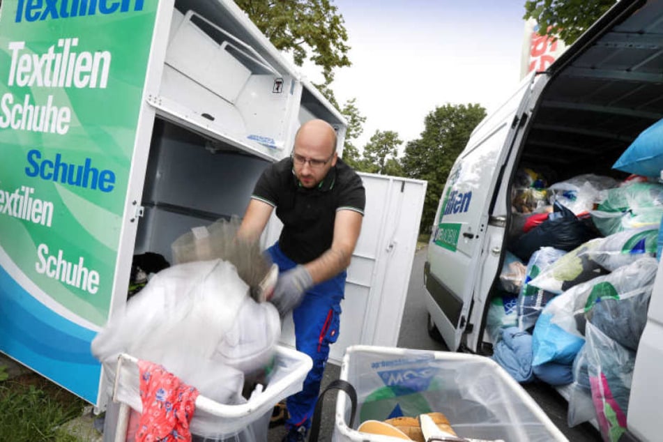 Ein Mitarbeiter holt die von den Dieben zurückgelassenen Kleider am Container am Real-Markt ab.