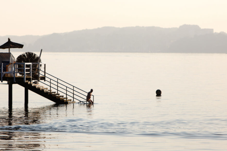 Ein Mann geht zum Schwimmen in die Kieler Förde (Symbolbild).